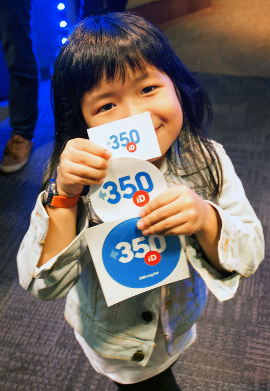 Photo of a young child holding up a handful of 350 Indonesia stickers