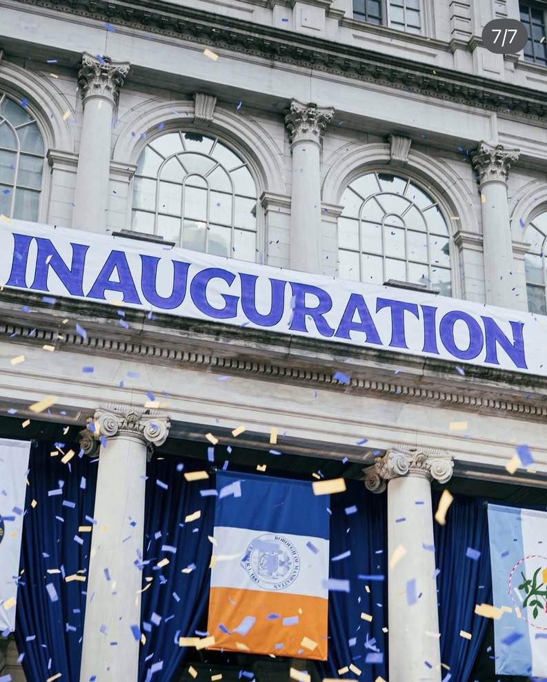 Large banner hanging from the front of city hall reading 'Inauguration'.